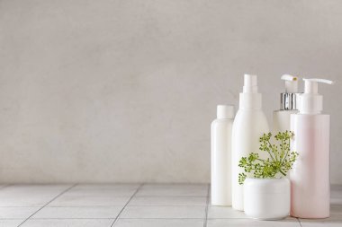 Beyaz karo zemin üzerinde şişe ve dereotu kozmetik ürünleri kavanozu ile kompozisyon, yakın çekim