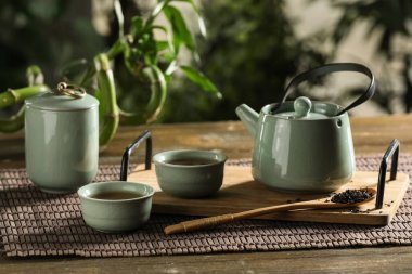 Bardaklı tepsi ve dışarıdaki ahşap masada sıcak çay.