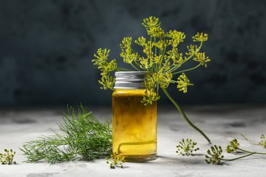 Gri masada bir şişe dereotu tohumu.