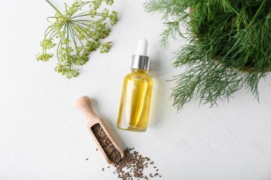 Beyaz arka planda bir şişe dereotu tohumu.