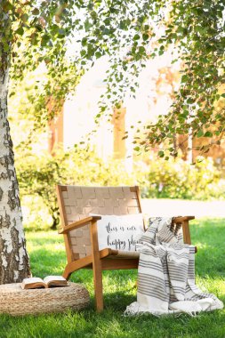 Battaniyeli, yastıklı ve parktaki, dışarıdaki kanepeli rahat hasır koltuk.