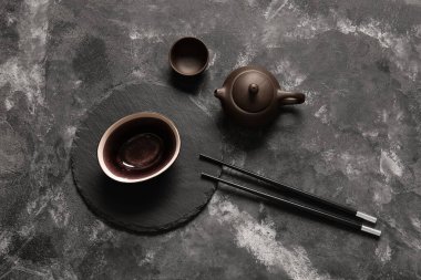 Çin sofrası kase, çaydanlık ve fincanla birlikte grunge siyah arka planda.