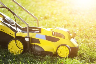 Yeşil çimlerin üzerinde modern çim biçme makinesi.