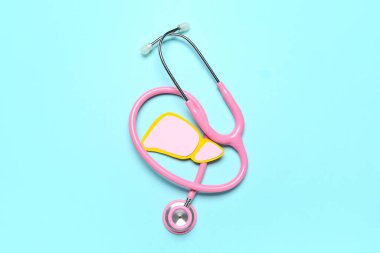 Mavi arka planda steteskoplu pembe kağıt karaciğer.