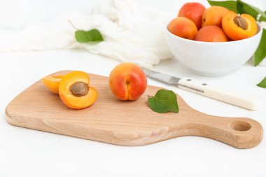 Beyaz arka planda taze kayısıları olan yemek ve kase.