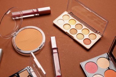 Güzel göz falı paletleri ve kahverengi arka planda farklı dekoratif kozmetikler.