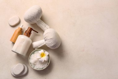Beyaz arka planda bitkisel poşetler, taşlar ve kozmetik ürünler içeren güzel bir spa kompozisyonu
