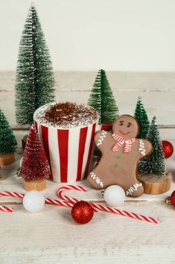 Kakao bardaklı kompozisyon, güzel Noel süslemeleri ve açık ahşap masada kurabiye.