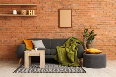 Oturma odasının içinde kanepe, puf ve masa var.