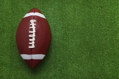 Yeşil çimlerde kahverengi rugby topu