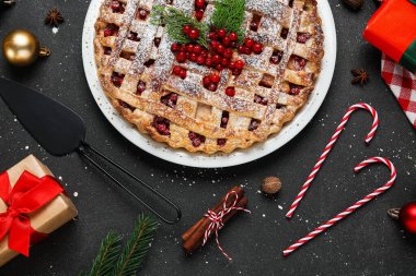 Siyah arka planda hediye kutuları ve baston şekerli yaban mersinli turta. Noel kutlaması