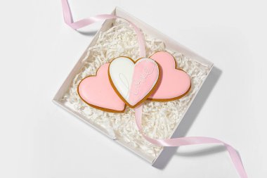 Gri arka planda kalp şeklinde kurabiyeler olan hediye kutusu. Sevgililer Günü kutlaması