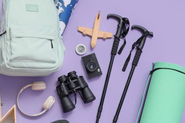 Yürüyüş direkleri, sırt çantaları ve yürüyüş ekipmanları leylak arka plan, üst görünüm