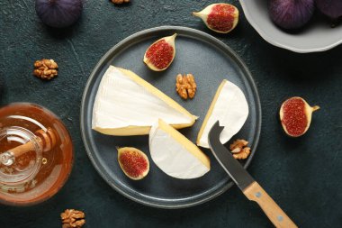 Lezzetli Camembert peyniri, taze incir ve mavi grunge arka planda ceviz, yakın plan.