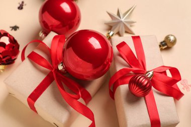 Bej arka planda Noel baloları ve hediye kutuları, yakın plan.