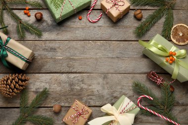 Noel hediye kutularından yapılmış çerçeve, köknar ağacı dalları ve ahşap arka planda dekor