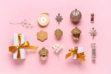 Hediye kutuları, Noel baloları ve pembe arka planda kurdele olan kompozisyon