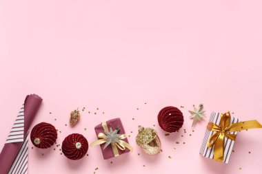 Güzel Noel baloları, hediye kutuları ve pembe arka planda konfetileri olan kompozisyon