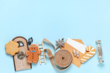 Zarflı kompozisyon, kurabiyeler ve mavi arka planda Noel oyuncakları, yakın plan