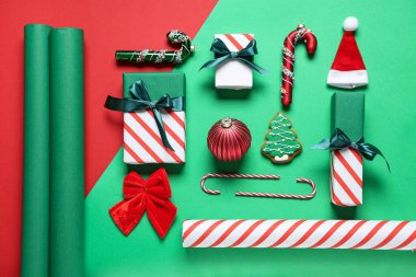 Noel toplarıyla kompozisyon, hediye kutuları ve renk arkaplanı üzerine paket kağıdı, yakın plan