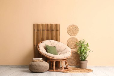 Rahat koltuğu ve bej duvarın yanındaki ahşap perdesi olan şık hasır pouf.