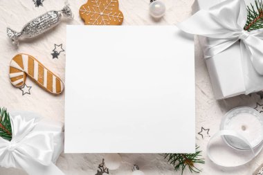 Noel süslemeleri, hediye kutuları, kurabiyeler ve grunge beyaz arka planda ambalaj malzemeleri olan boş tebrik kartı