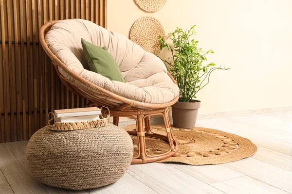 Rahat koltuğu ve bej duvarın yanındaki ahşap perdesi olan şık hasır pouf.