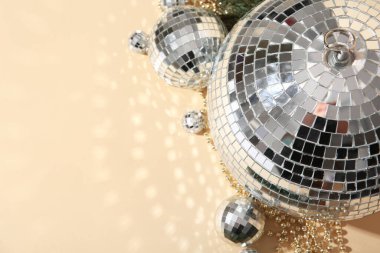 Disco balls with Christmas decor on beige background, closeup