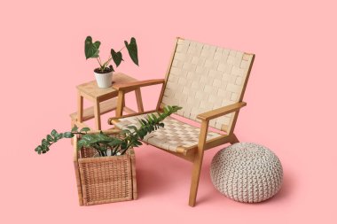 Taburesi, bitkisi ve pembesi olan tahta koltuk.