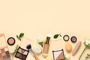 Beyaz gül çiçekleri, makyaj ürünleri ve bej arkaplanda fırçalar