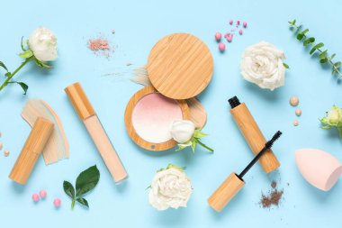 Beyaz gül çiçekleri, makyaj ürünleri ve mavi arkaplanda örnekler