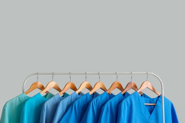 Açık arkaplanda tıbbi üniformalı raflar