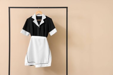 Bej arkaplanda hizmetçi üniforması var.