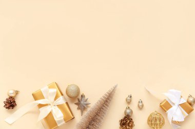 Composition with golden Christmas balls and gift boxes on beige background