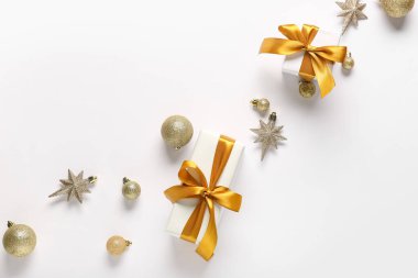 Composition with golden Christmas balls and gift boxes on white background