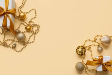 Sarı arka planda güzel altın Noel topları, boncuklar ve hediye kutularından yapılmış çerçeve