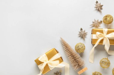 Beautiful composition with gift boxes, golden Christmas balls and decorative tree on white background