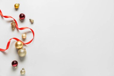 Beyaz arka planda kırmızı ve altın renkli Noel toplarıyla güzel bir kompozisyon.