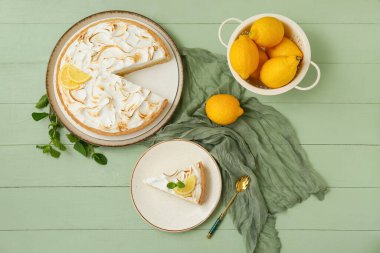 Plate with tasty lemon pie on green wooden background, closeup