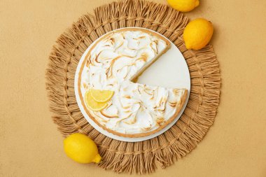 Plate with tasty lemon pie on beige grunge background, closeup