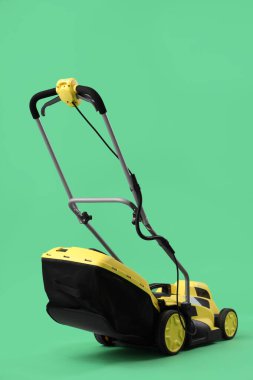 Yeşil arka planda modern çim biçme makinesi