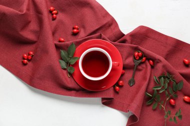 Beyaz arka planda sıcak gül kalçası çayı ve böğürtlen.