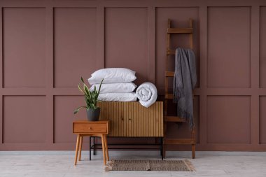 Oturma odasında sehpa, battaniye ve yastıklı tuvalet.