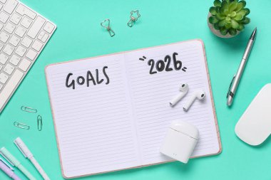 2026 gollü defter, kulaklıklar ve yeşil arka planda bilgisayar klavyesi