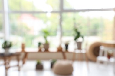 Ahşap masaları ve yeşil bitkileri olan bulanık ışık odası manzarası