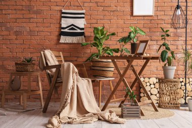 Odanın içinde tahta sandalye, masa ve bitkiler var.