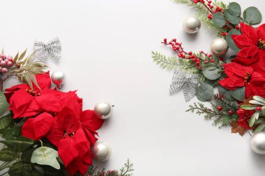 Beyaz arkaplanda Noel çiçekleri ve dekorasyonlarından yapılmış çerçeve