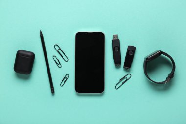 Cep telefonu, kırtasiye ve turkuaz arka planda modern flaş bellek bileşimi