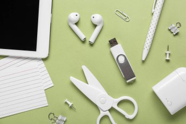 Yeşil arkaplanda tablet bilgisayar, kırtasiye ve modern flash disk bileşimi