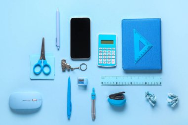 Mavi arkaplanda cep telefonu, kırtasiye ve modern flaş bellek bileşimi